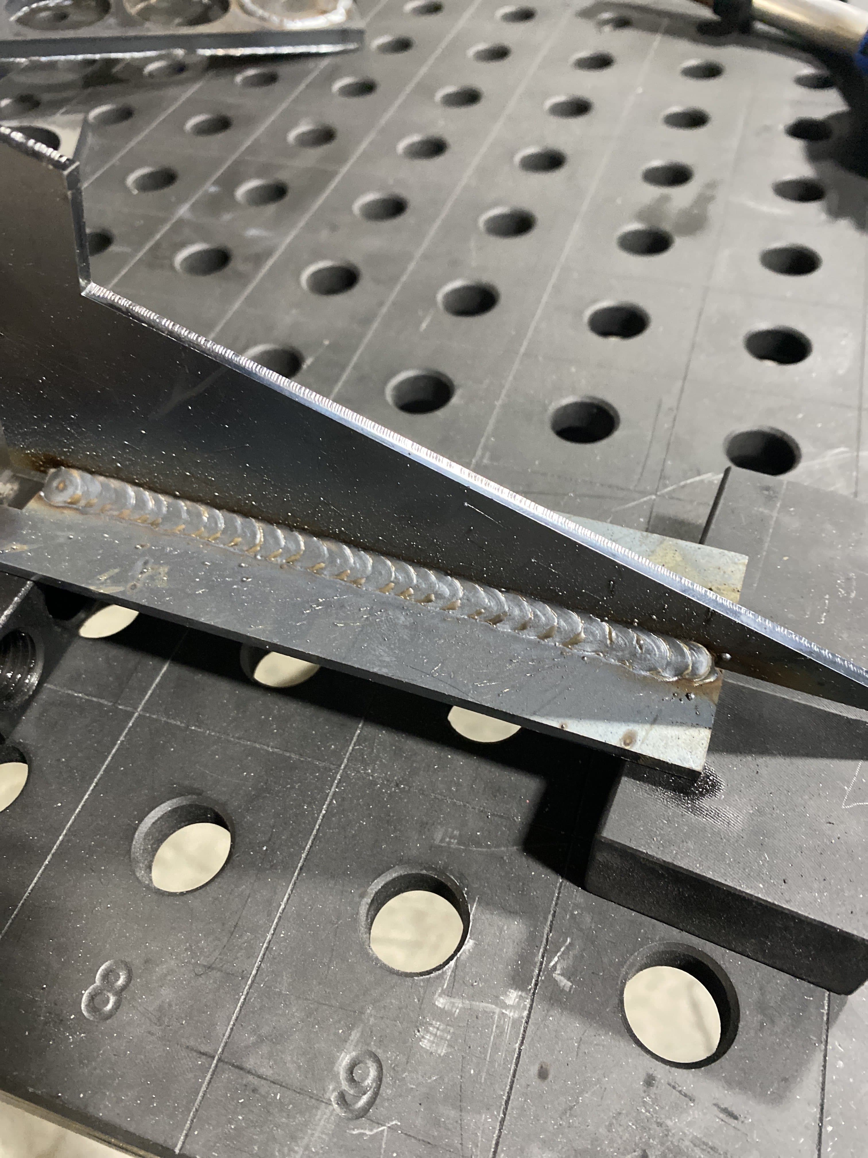 Steel weldment fixture showing precision welding and drilled alignment holes